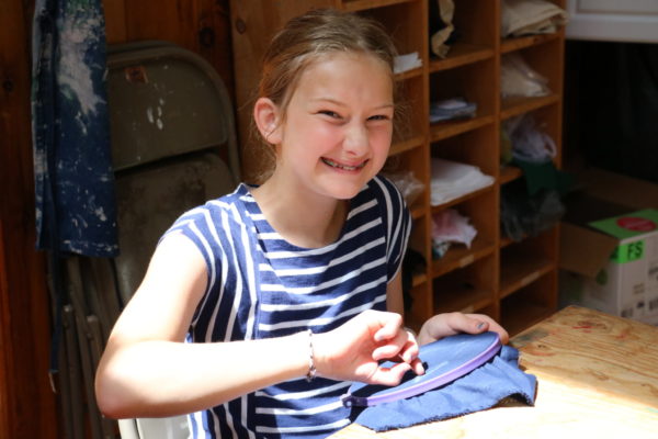 embroidering part of fabrics class at camp