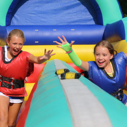 two girls playing in inflatable obstacle course at camp Kippewa