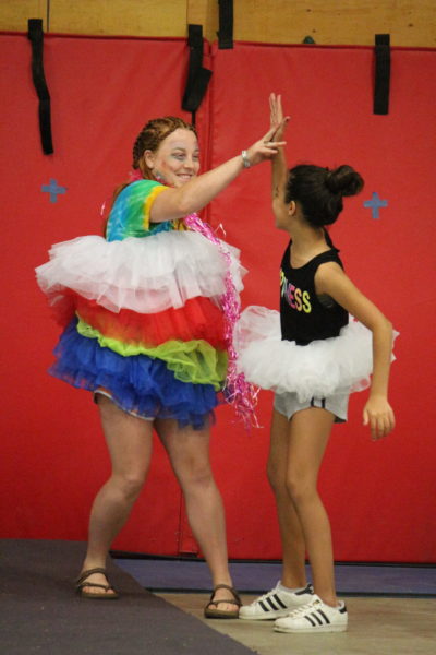 high five counselor and camper in tutus
