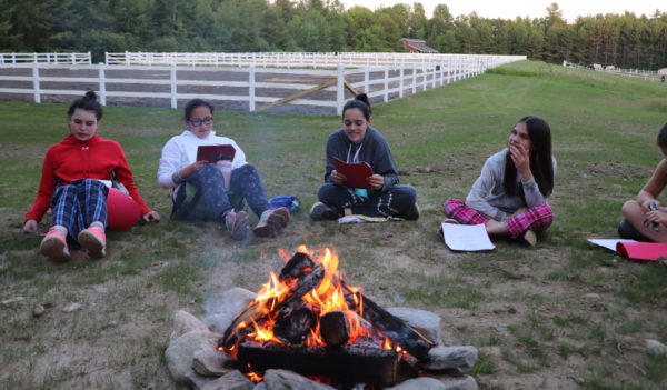 Equestrian Academy horseback riding campers enjoy sharing stories around the campfire in Maine