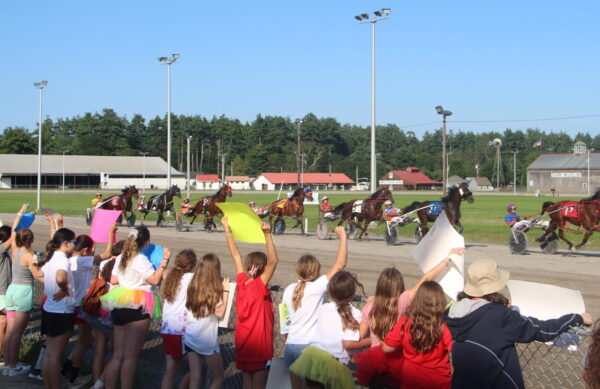 Equestrian Academy campers cheering on Maine standardbred racers